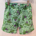 Green shorts featuring a comic-book style print of the Hulk, including angry expressions, 'ANGRY SAMMY' text, and comic-style doodles, hanging from a hanger with metal clips against a textured wall.